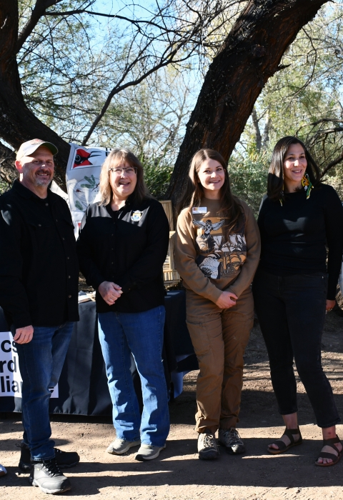 seven people stand together smiling in front of a podium that says Tucson urban bird treaty coaltion
