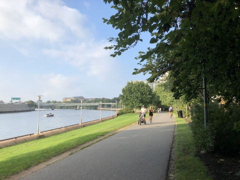 People walk along a riverside trail