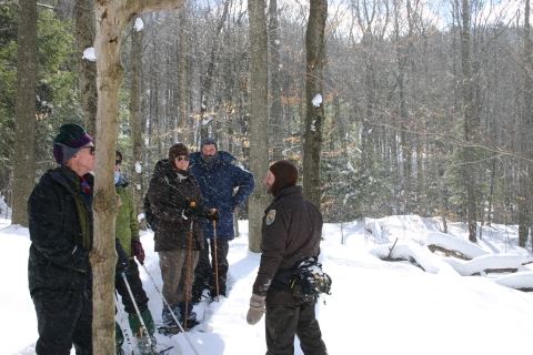 USFWS employee Ken Sturm leads a snowshoe walk while snowing.