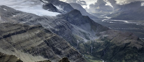 Sloped mountains rise from a river valley.