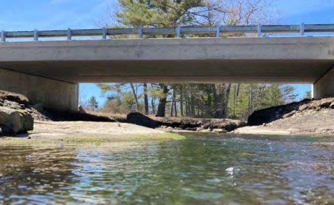 Concrete bridge spanning the full bank width of a tidal river