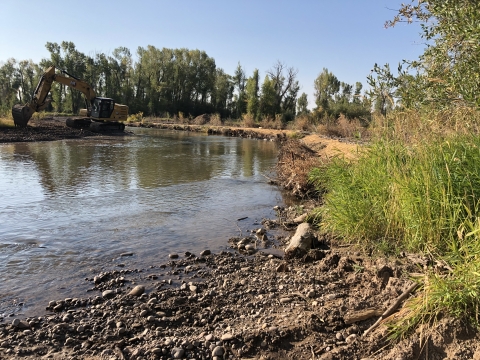 A river with construction equipment on one side