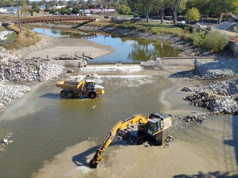 Heavy equipment operates in a river to remove a dam and restore a natural river
