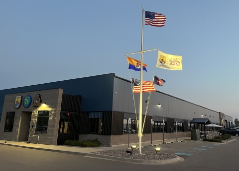 5 flags on flag pole with US at top