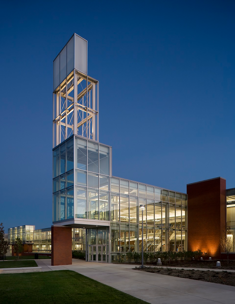 A building on a college campus illuminated at dusk