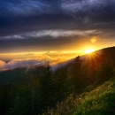 The rising sun paints a row of mountains beautiful shades of purple.