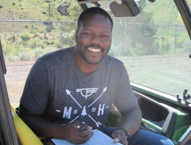 Rikeem Sholes, fish biologist, sitting in an OHV