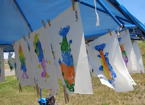 Colorful fish art hanging from a string. 