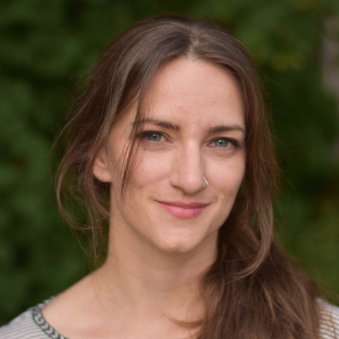 A white woman with brown hair smiles.