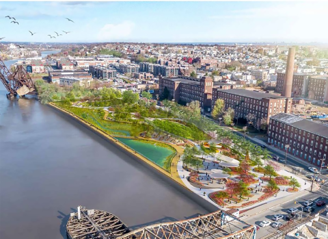 An aerial view of a city with a green park near the water