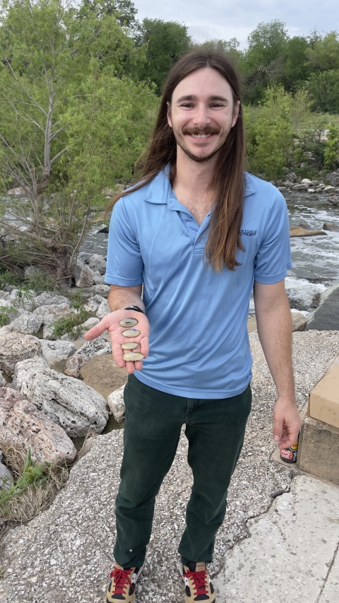 A biologist holds yellow sandshell freshwater mussels