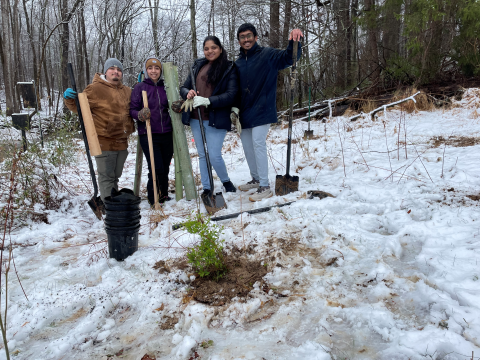 Volunteers pose with a shrub they planted. 
