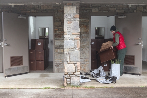 Woman taking a box out of a storage space to set it on the sidewalk
