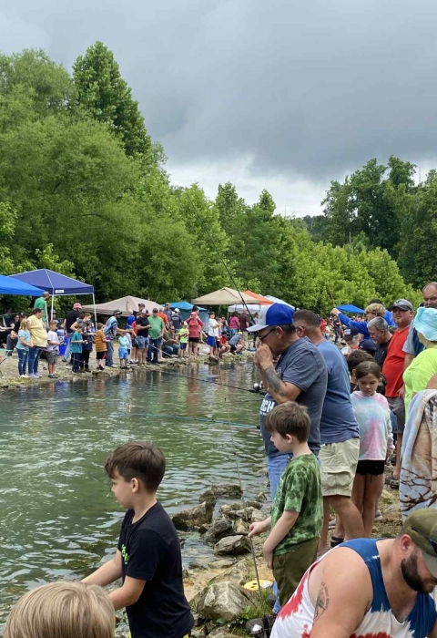 Crowd lining creek bank fishing