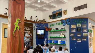 Kids looking at a video on the "Kids Corner" at Santa Ana National Wildlife Refuge.