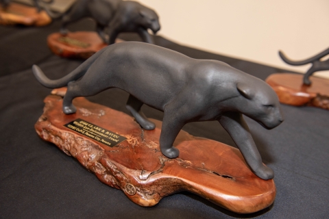 A statuette of a jaguar on a wooden pase