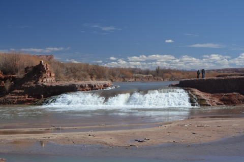 Image of 2 researchers standing on the land next to a waterfall