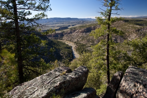 An aerial image of a river surrounded by plains and hills