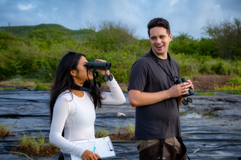 Nikki Imamura and Czachura, biologists with the Pacific Islands Fish and Wildlife Office, observe waterbirds at Bellows Air Force Base.