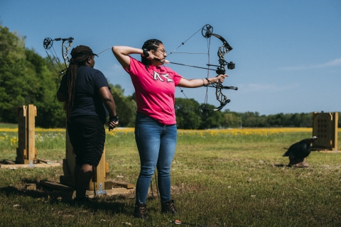 Archer aims as target on outdoor range 
