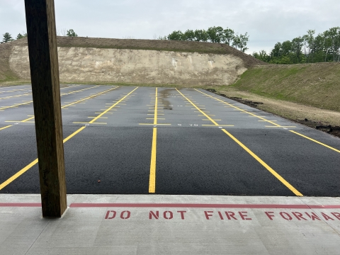 View of range empty firing line with earth berm in the background