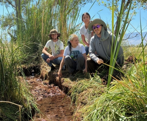 Youth Conservation Corps crew performing maintenance on a grassy field at Stillwater NWR