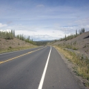 View of a two-lane highway cutting through Alaskan wilderness.