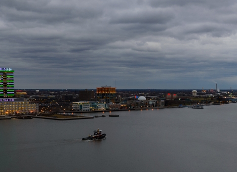 an aerial view of a city and a river at dusk with cloudy skies
