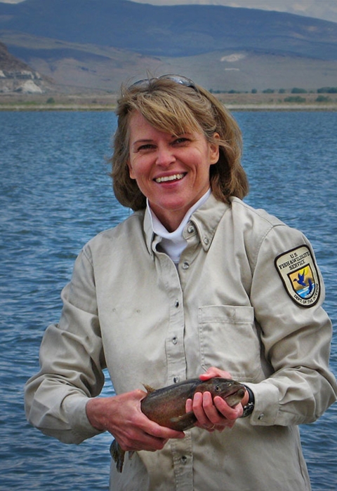 a woman holding a large fish
