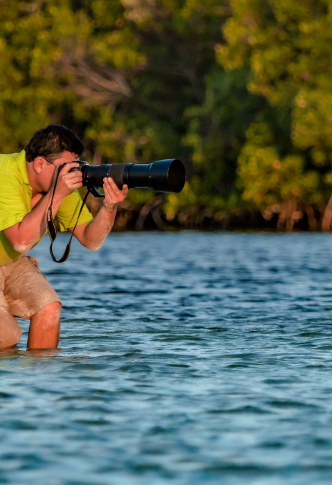 Ernesto Gomez taking photos of wildlife in a wetland