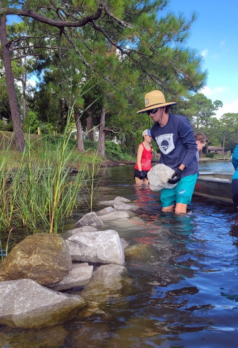 Choctawhatchee Basin Alliance staff building a living shoreline with Spartina alterniflora growing behind the reef.