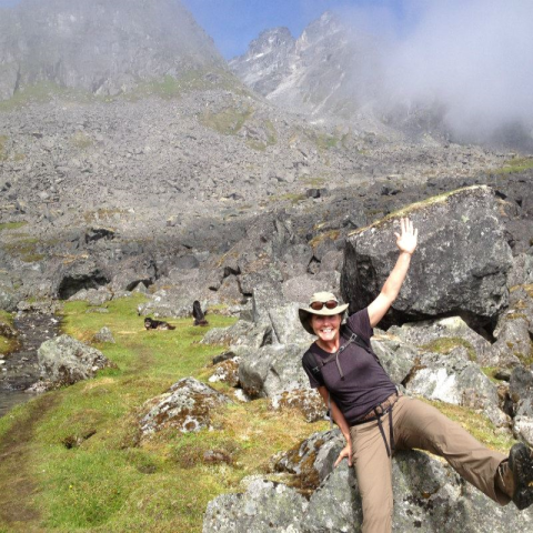 Jennie sits on a rock on a hiking trail in Hatchers Pass.