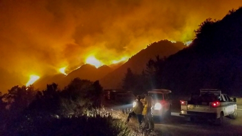 A fire sweeps across a mountainside