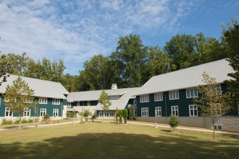 three green buildings with a blue sky in background