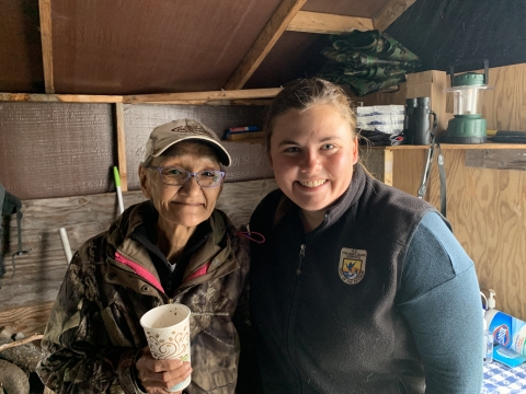 Two women stand together in a cabin