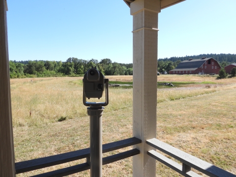 Spotting scope pointed at a pond with a barn in the background