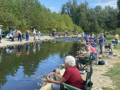 Elderly people fishing at stream