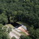 A metal structure dams a ditch and prevents water from flowing out.