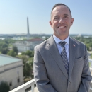 man on balcony with Washington Monument in background