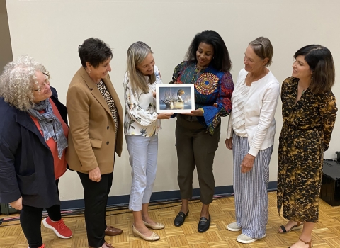 A group of six women admire the winning duck stamp artwork.